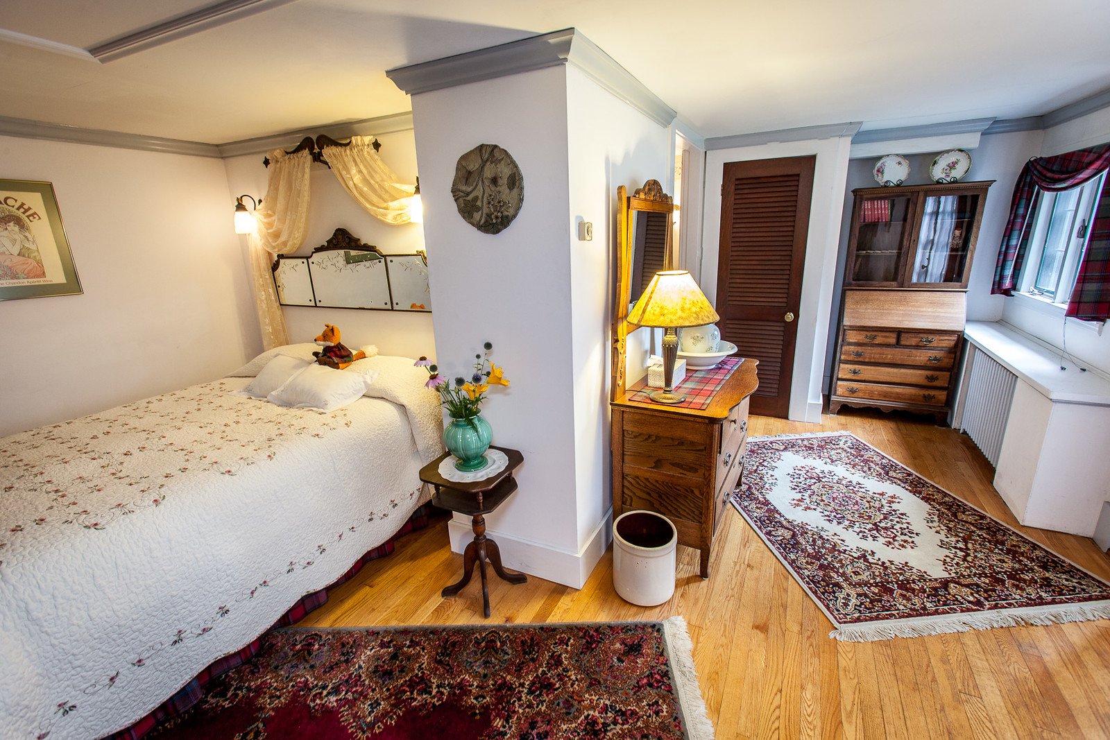 Terrace Room with a mirrored antique headboard, sheer canopy drape, and a floral quilted coverlet